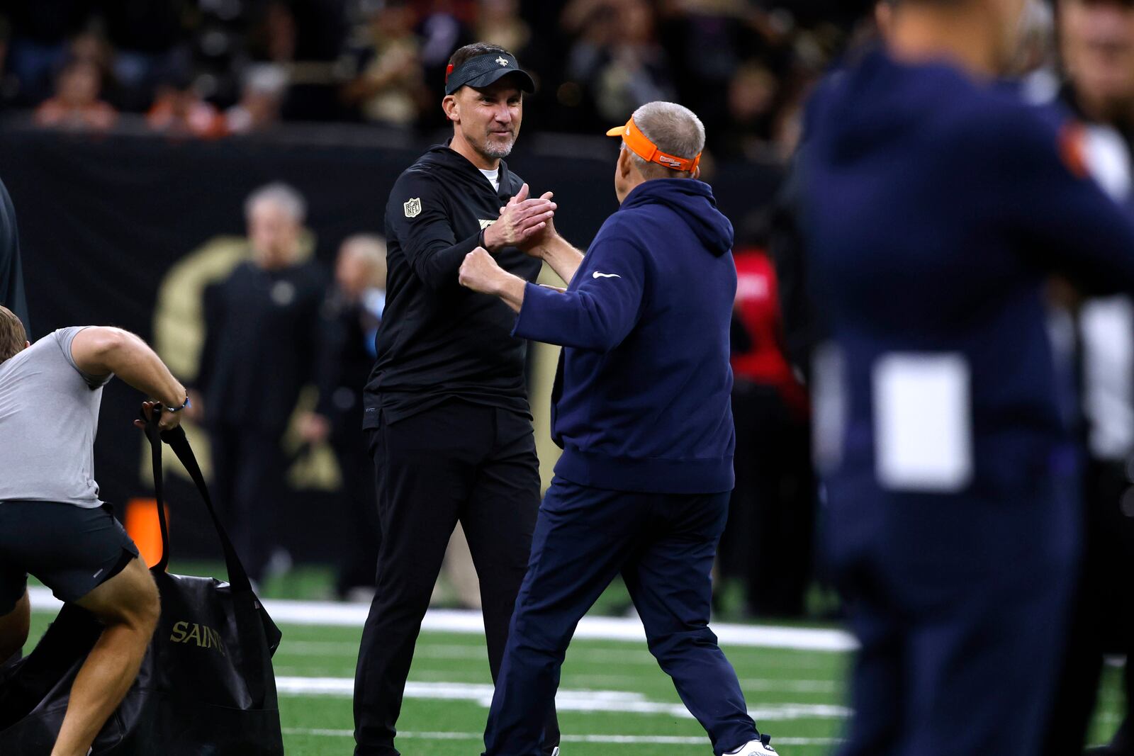 New Orleans Saints head coach Dennis Allen, left, greets Denver Broncos head coach Sean Payton before an NFL football game, Thursday, Oct. 17, 2024, in New Orleans. (AP Photo/Butch Dill)