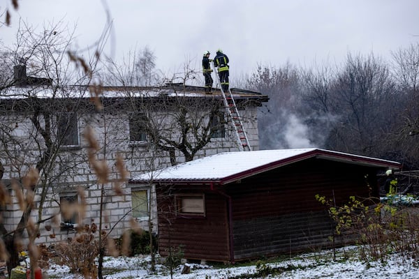 Lithuanian Emergency Ministry employees work near the place where a DHL cargo plane crashed into a house near the Lithuanian capital Vilnius, Lithuania, Lithuania, Monday, Nov. 25, 2024. (AP Photo/Mindaugas Kulbis)