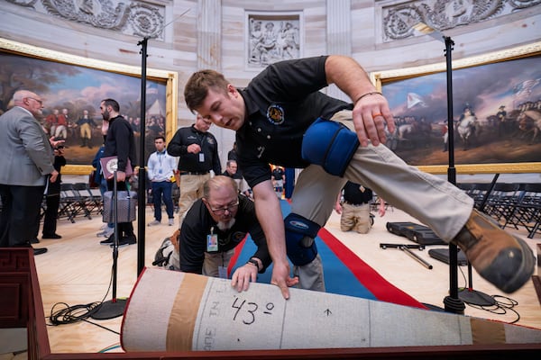 Organizers work to move the Inauguration Day swearing-in ceremony into the Capitol Rotunda due to expected frigid weather in Washington, Saturday, Jan. 18, 2025. (AP Photo/J. Scott Applewhite)