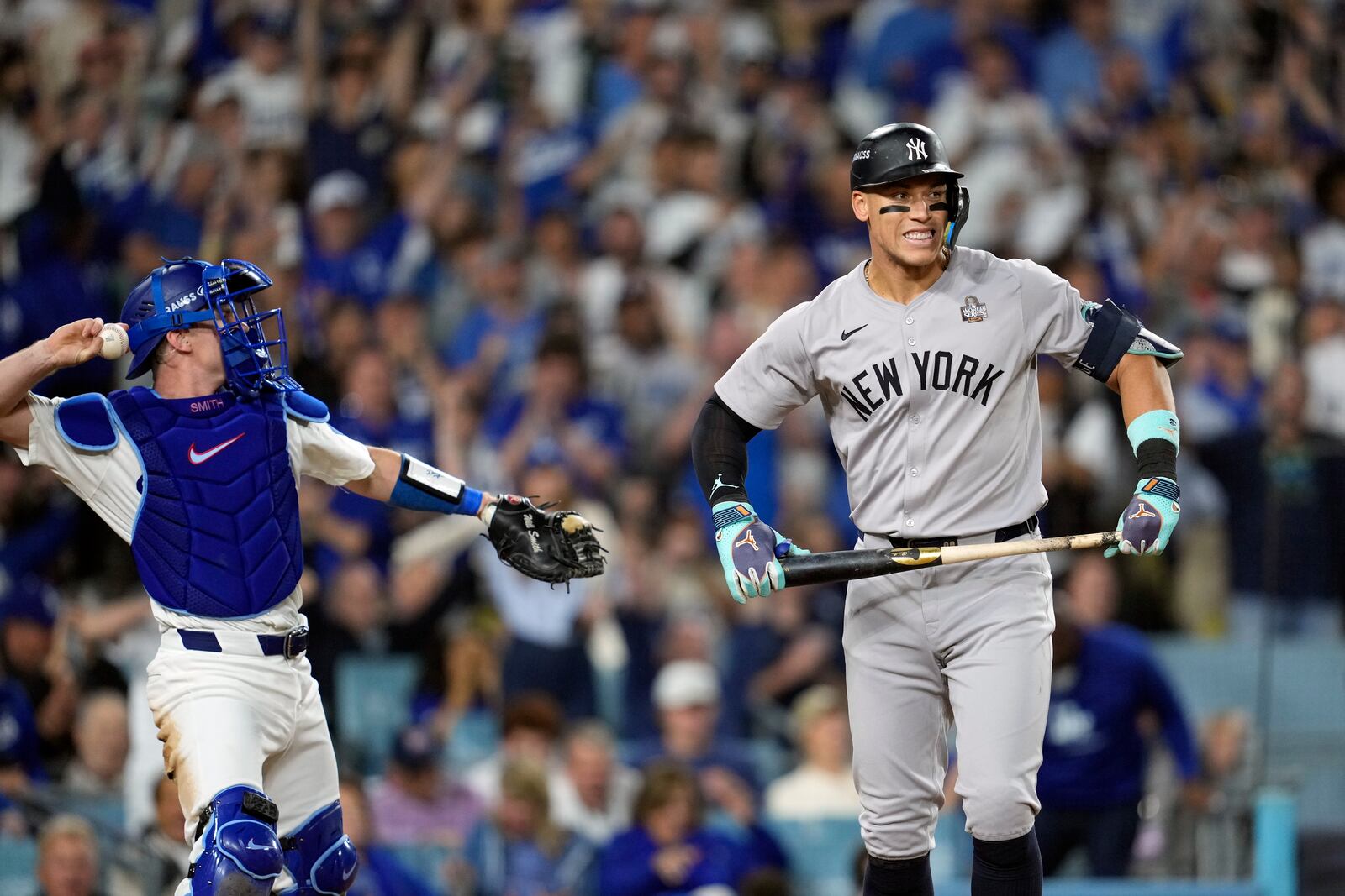 New York Yankees' Aaron Judge, right, reacts after striking out as Los Angeles Dodgers catcher Will Smith throws the ball around the infield during the sixth inning in Game 2 of the baseball World Series, Saturday, Oct. 26, 2024, in Los Angeles. (AP Photo/Godofredo A. Vásquez)