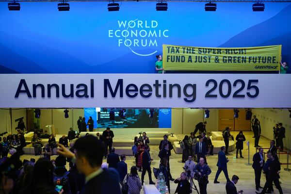 Greenpeace activists show a poster during a protest at the Annual Meeting of World Economic Forum in Davos, Switzerland, Tuesday, Jan. 21, 2025. (AP Photo/Markus Schreiber)