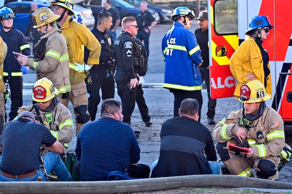 Firefighters tend to people after a plane crashed through the roof of a building near Fullerton airport on Thursday, Jan. 2, 2025, in Fullerton, Calif. (Jeff Gritchen, Orange County Register/The Orange County Register via AP)