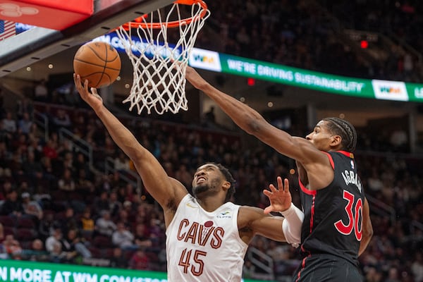 Cleveland Cavaliers' Donovan Mitchell (45) shoots as Toronto Raptors' Ochai Agbaji (30) defends during the second half of an NBA basketball game in Cleveland, Sunday, Nov 24, 2024. (AP Photo/Phil Long)