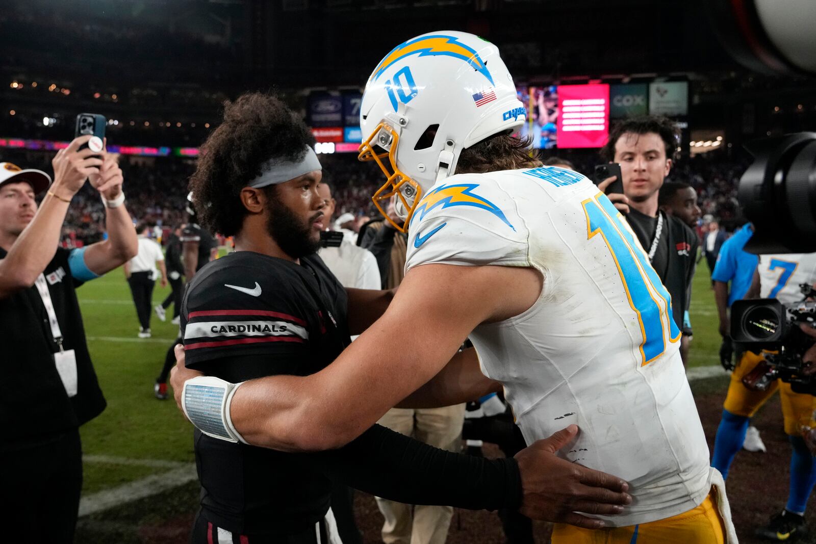 Arizona Cardinals quarterback Kyler Murray, left, talks with Los Angeles Chargers quarterback Justin Herbert (10) after an NFL football game, Monday, Oct. 21, 2024, in Glendale Ariz. (AP Photo/Matt York)