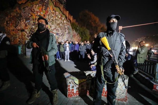 Security forces of the new Syrian government secure the area around group of Alawite protesters in the Mazzeh district in Damascus Wednesday Dec. 25, 2024. The minority Alawite community is an offshoot of Shiite Islam that form President Bashar Assad belongs to. (AP Photo/Omar Sanadiki)