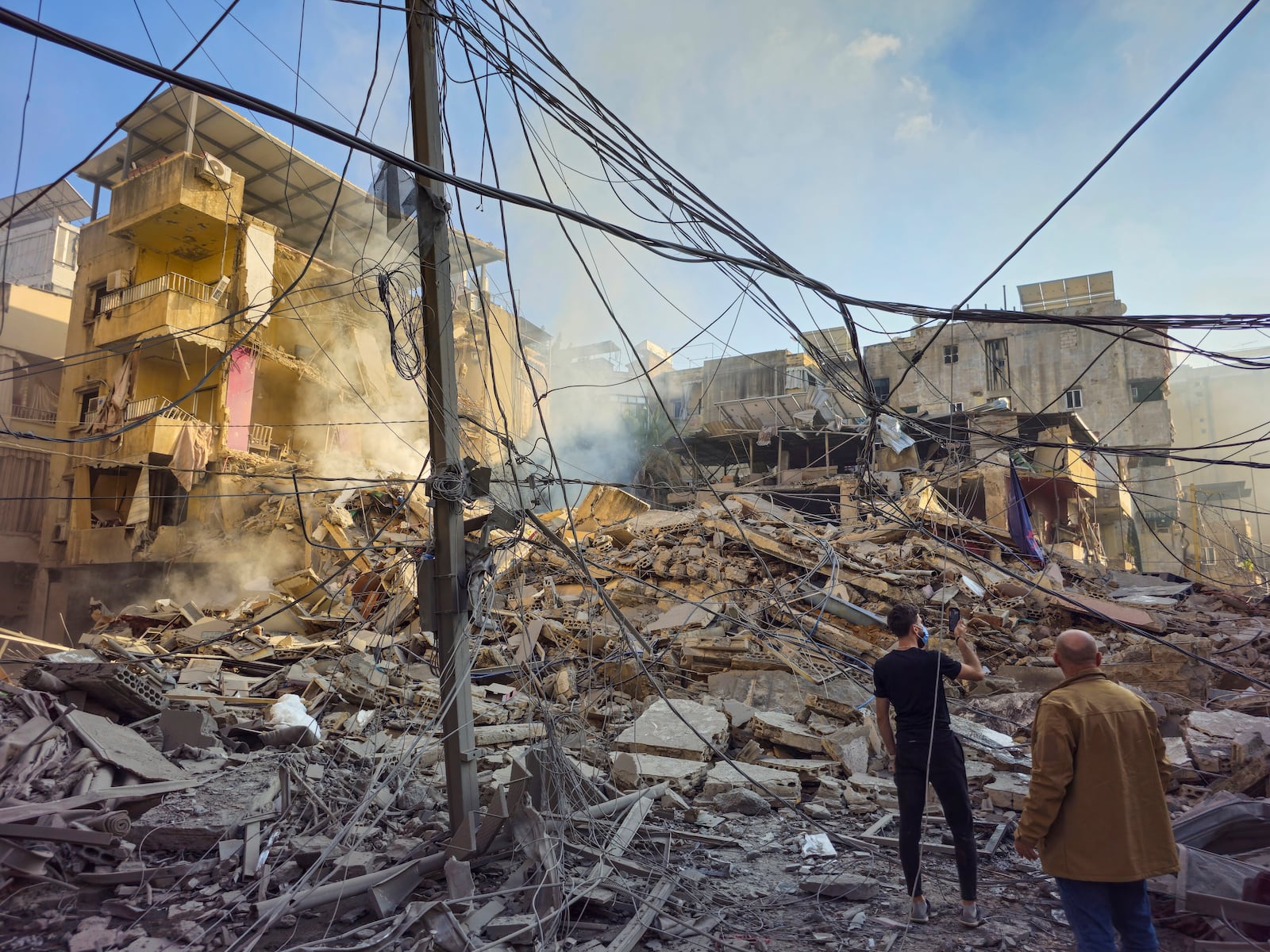 Residents check the site of an Israeli airstrike in Dahiyeh, Beirut, Lebanon, Wednesday, Nov. 13, 2024. (AP Photo/Hassan Ammar)