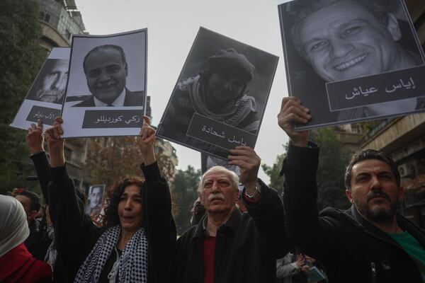 Mourners hold up portraits of missing opposition activists during the funeral of Syrian activist Mazen al-Hamada iin Damascus Thursday Dec. 12, 2024. Al-Hamad's mangled corpse was found wrapped in a bloody sheet in Saydnaya prison. He had fled to Europe but returned to Syria in 2020 and was imprisoned upon arrival. (AP Photo/Ghaith Alsayed)