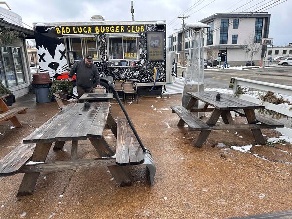 Andy Atkins removes snow from the outdoor seating area for his food truck Bad Luck Burger Club in Nashville, Tenn. on Saturday, Jan.11, 2025. (AP Photo/Kristin M. Hall)