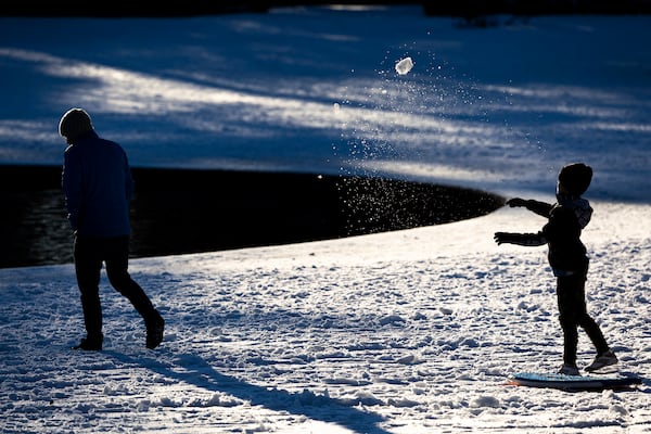 A child throws a snowball at his father in Hampton Park after a winter storm dropped ice and snow Wednesday, Jan. 22, 2025, in Charleston, S.C. (AP Photo/Mic Smith)