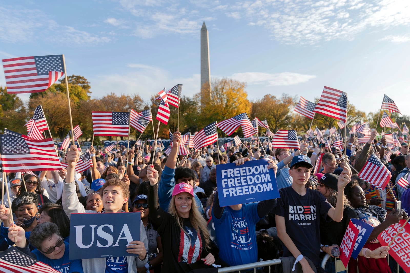 With the Washington Monument in the back ground supporters of Democratic presidential nominee Vice President Kamala Harris wave they American flags as they attend a campaign rally in Washington, Tuesday, Oct. 29, 2024. (AP Photo/Jose Luis Magana)