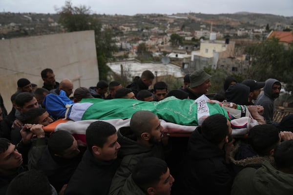 Mourners carry the body of Palestinian Zein Atatrah, 18, wrapped with a Hamas flag, during his funeral in the West Bank town of Ya'bad Friday, Dec. 27, 2024. (AP Photo/Nasser Nasser)