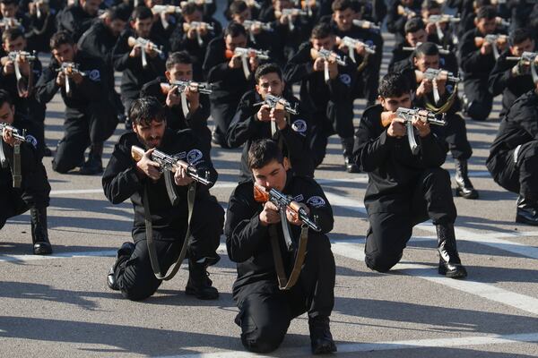 Recruits for the new government's police force hold their weapons in a firing position during a training and graduation session at the Police College in Damascus, Syria, Tuesday Jan. 14, 2025.(AP Photo/Omar Albam)