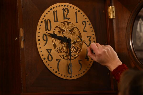 Bethany Gill winds a clock in the Pennsylvania Supreme Court chamber, Dec. 13, 2024, in Harrisburg, Pa. It's one of 273 clocks in Pennsylvania's ornate state Capitol complex buildings that must be wound by hand. (AP Photo/Marc Levy)