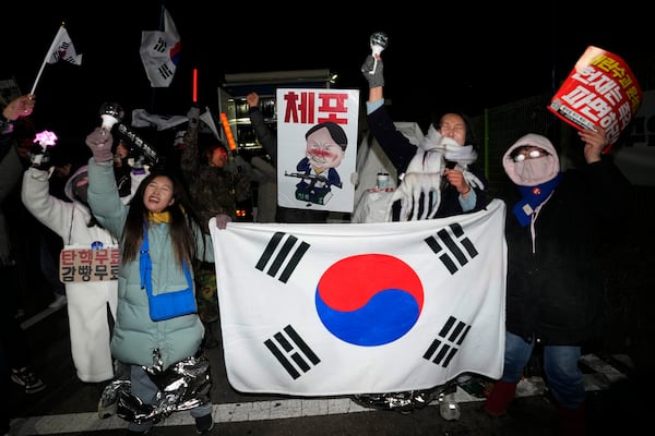 Protesters against impeached South Korean President Yoon Suk Yeol cheer after a court issued a warrant to formally arrest Yoon over his failed martial law bid, in front of a detention center in Uiwang, South Korea, Sunday, Jan. 19, 2025. (AP Photo/Ahn Young-joon)