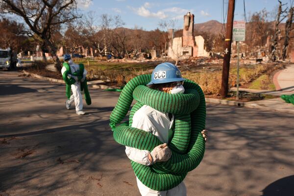 A member of the California Conservation Corps works in the rubble of the Palisades Fire in the Pacific Palisades section of Los Angeles, Monday, Jan. 27, 2025. (AP Photo/Jae C. Hong)