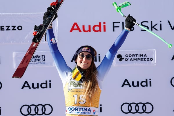 Italy's Sofia Goggia celebrates on the podium after winning an alpine ski, women's World Cup downhill, in Cortina d'Ampezzo, Italy, Saturday, Jan. 18, 2025 (AP Photo/Alessandro Trovati)