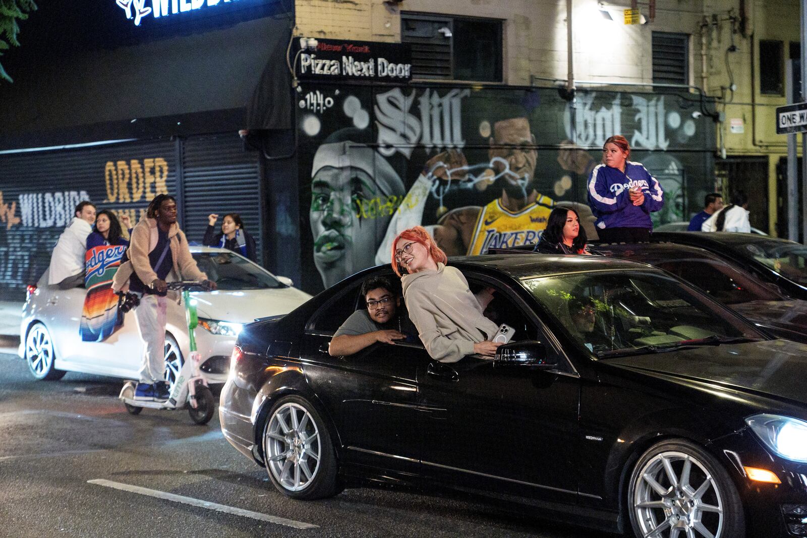 Fans celebrate on the streets after the Los Angeles Dodgers won against the New York Yankees in the baseball World Series Wednesday, Oct. 30, 2024, in downtown Los Angeles. (AP Photo/Damian Dovarganes)