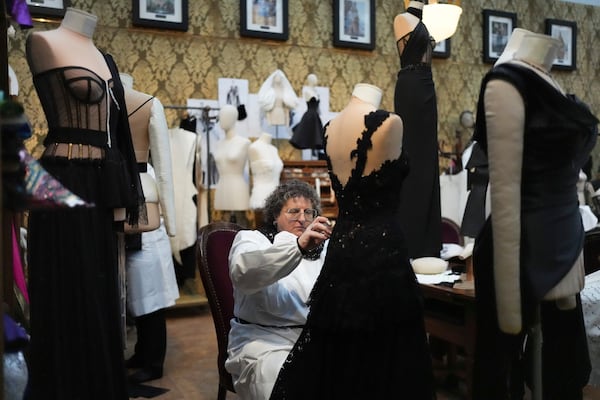 A seamstress works on a dress during the exhibition "From the Heart to the Hands: Dolce&Gabbana" at the Grand Palais, in Paris, Thursday, Jan. 9, 2025. (AP Photo/Thibault Camus)