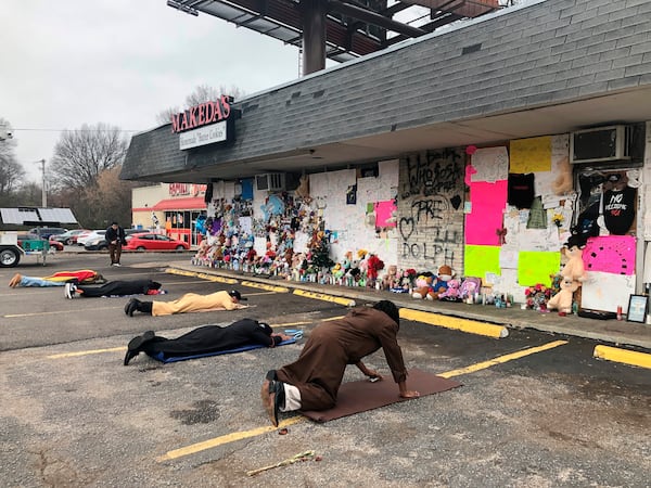 FILE - Mourners lie on the ground and pray in front of a memorial to slain rapper Young Dolph at Makeda's Homemade Cookies on Wednesday, Dec. 15, 2021, in Memphis, Tenn. (AP Photo/Adrian Sainz, File)