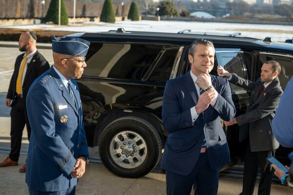 Defense Secretary Pete Hegseth, center right, shows his bracelet as he is welcomed to the Pentagon by Chairman of the Joint Chiefs of Staff Gen. Charles Q. Brown Jr., Monday, Jan. 27, 2025 in Washington. (AP Photo/Kevin Wolf)