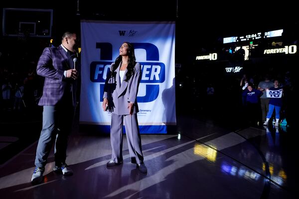 Former Washington guard and current Las Vegas Aces player Kelsey Plum, right, reacts with Washington athletic director Pat Chun, left, during her jersey retirement ceremony during halftime of an NCAA college basketball game between Washington and Purdue Saturday, Jan. 18, 2025, in Seattle. (AP Photo/Lindsey Wasson)