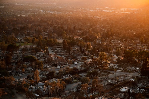 Trucks drive through a neighborhood destroyed by the Eaton Fire, Tuesday, Jan. 14, 2025, in Altadena, Calif. (AP Photo/John Locher)