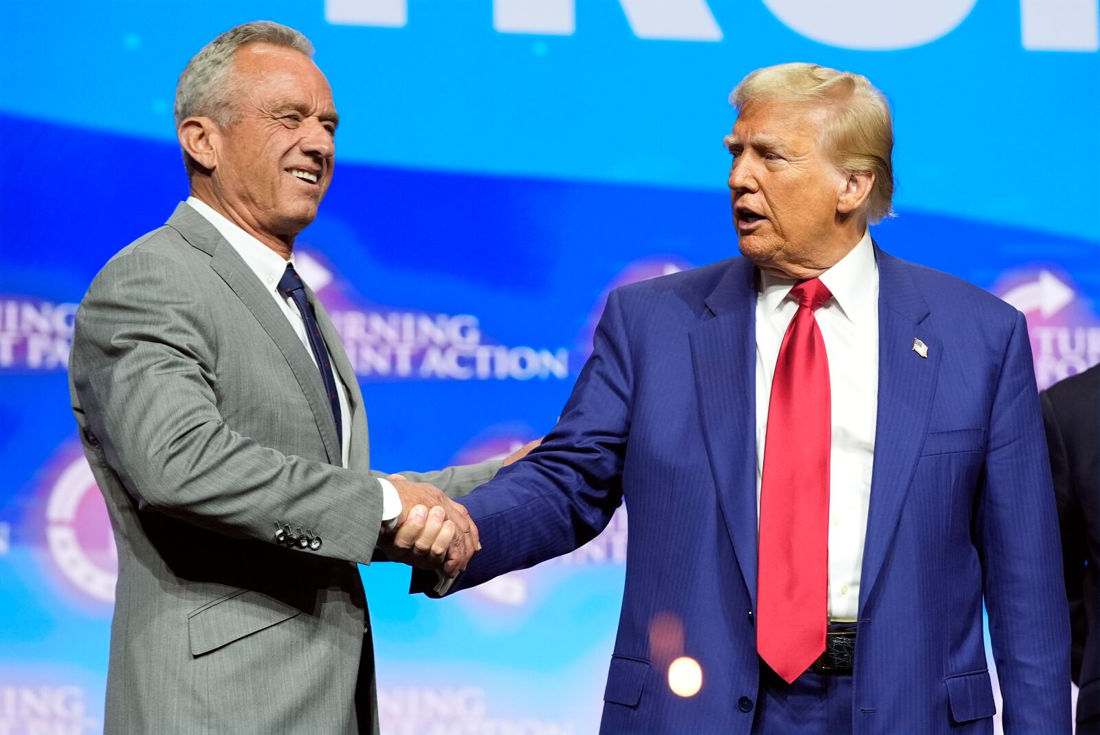 Republican presidential nominee former President Donald Trump shakes hands with Robert F. Kennedy Jr., at a Turning Point Action campaign rally, Wednesday, Oct. 23, 2024, in Duluth, Ga. (AP Photo/Alex Brandon)