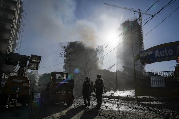 Civil defense workers check a building that collapsed after it was hit in an Israeli airstrike in Chiyah, south of Beirut, Lebanon, Sunday, Nov. 17, 2024. (AP Photo/Bilal Hussein)