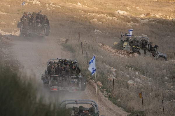 FILE - Israeli soldiers cross the security fence moving towards the so-called Alpha Line that separates the Israeli-annexed Golan Heights from Syria, in the town of Majdal Shams, Sunday, Dec. 15, 2024. (AP Photo/Matias Delacroix, File )