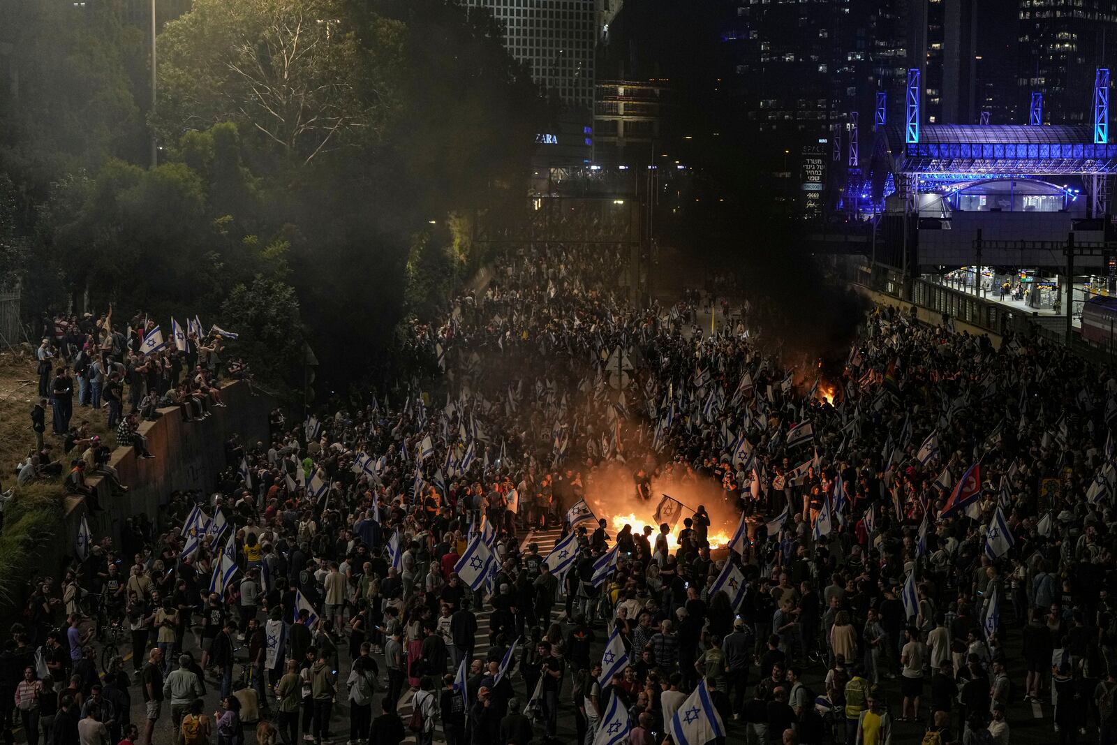 Israelis light a bonfire during a protest after Prime Minister Benjamin Netanyahu has dismissed his popular defense minister Yoav Gallant, in Tel Aviv, Israel, Tuesday, Nov. 5, 2024. (AP Photo/Oded Balilty)