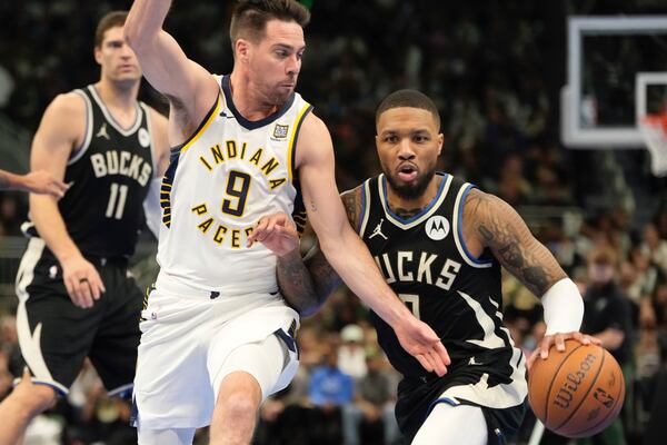 Milwaukee Bucks' Damian Lillard tries to get past Indiana Pacers' T.J. McConnell during the first half of an Emirates NBA cup tournament basketball game Friday, Nov. 22, 2024, in Milwaukee. (AP Photo/Morry Gash)