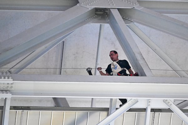 A employee labors on the catwalk of AT&T Stadium prior to an NFL football game between the Dallas Cowboys and the Houston Texans, Monday, Nov. 18, 2024, in Arlington. (AP Photo/Jerome Miron)