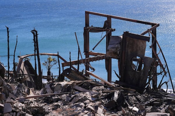 Metal debris stands at a home destroyed by the Palisades Fire in Malibu, Calif., Sunday, Jan. 12, 2025. (AP Photo/Mark J. Terrill)