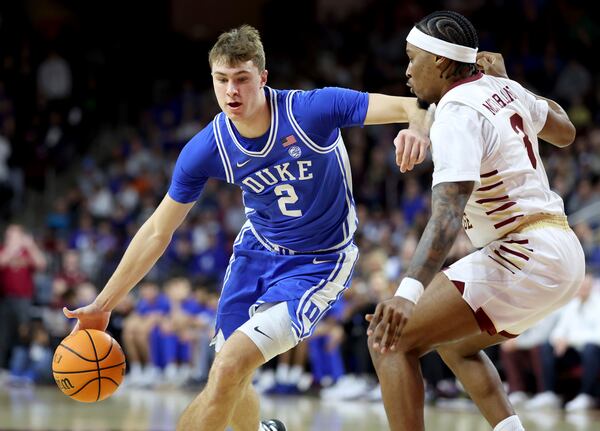 Duke guard Cooper Flagg (2) dribbles around Boston College guard Roger McFarlane (3) during the first half of an NCAA college basketball game Saturday, Jan. 18, 2025, in Boston. (AP Photo/Mark Stockwell)