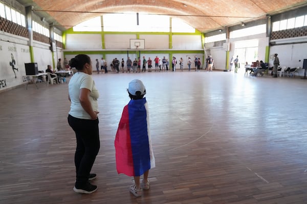 Voters line up at a polling station during the presidential run-off election in Montevideo, Uruguay, Sunday, Nov. 24, 2024. (AP Photo/Matilde Campodonico)