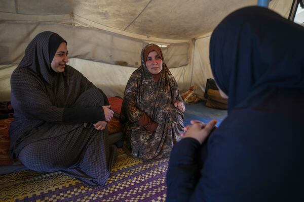 Alaa Hamami, right, chats with her sister Baraa, left, and her neighbor and friend Wafaa inside her tent at a camp for displaced Palestinians in Deir al-Balah, Gaza Strip, on Dec. 18, 2024. (AP Photo/Abdel Kareem Hana)