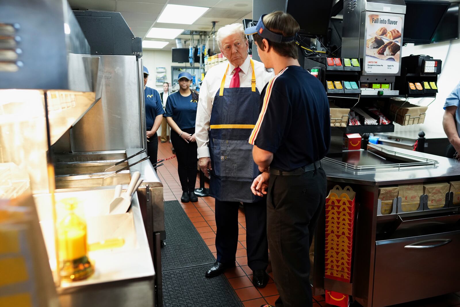 Republican presidential nominee former President Donald Trump, center, speaks with an employee behind the counter during a visit to McDonald's in Feasterville-Trevose, Pa., Sunday, Oct. 20, 2024. (Doug Mills/The New York Times via AP, Pool)