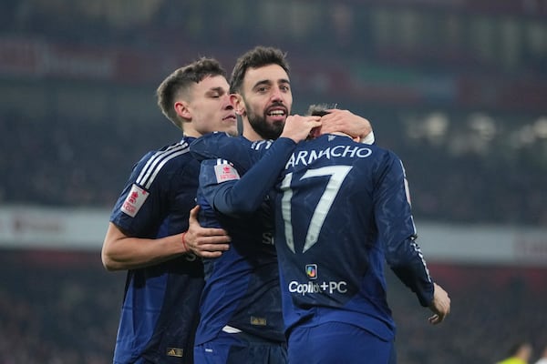 Manchester United's Bruno Fernandes, centre, celebrates with his teammates after scoring his side's opening goal during the English FA Cup soccer match between Arsenal and Manchester United at the Emirates stadium in London, Sunday, Jan. 12, 2025. (AP Photo/Kin Cheung)