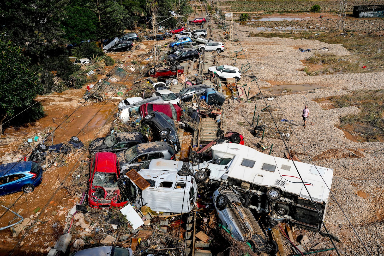 A man stands next to flooded cars piled up in Valencia, Spain, Thursday, Oct. 31, 2024. (AP Photo/Manu Fernandez)