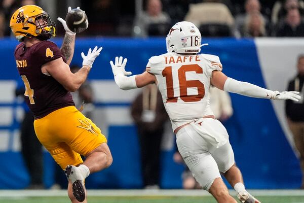 Arizona State running back Cam Skattebo (4) makes the catch against Texas defensive back Michael Taaffe (16) during the second half in the quarterfinals of a College Football Playoff game, Wednesday, Jan. 1, 2025, in Atlanta. Texas won 39-31 in two overtime periods. (AP Photo/John Bazemore)