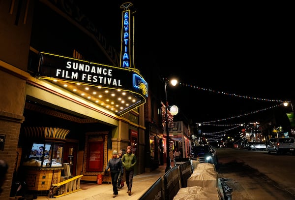 Pedestrians walk underneath the marquee of the Egyptian Theatre before the start of the Sundance Film Festival on Wednesday, Jan. 22, 2025, in Park City, Utah. (AP Photo/Chris Pizzello)