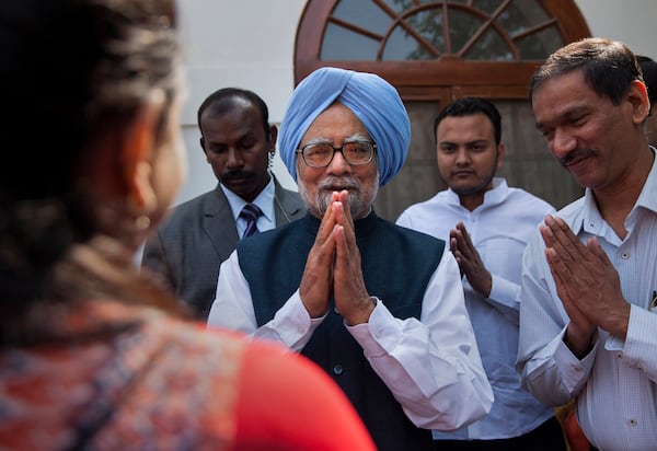 FILE - Former Indian prime minister Manmohan Singh, center, gestures after a short meeting with the newly elected office bearers of "National Students' Union Of India" (NSUI), who called on him at his residence in New Delhi, India, Tuesday, March 17, 2015. (AP Photo/Tsering Topgyal, File)