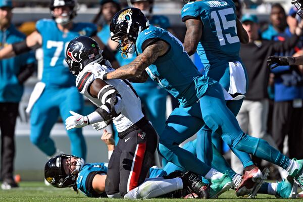 Jacksonville Jaguars tight end Evan Engram (17, right) jumps on Houston Texans linebacker Azeez Al-Shaair (0) after his late hit on quarterback Trevor Lawrence (16) during the first half of an NFL football game Sunday, Dec. 1, 2024, in Jacksonville, Fla. (AP Photo/Phelan M. Ebenhack)