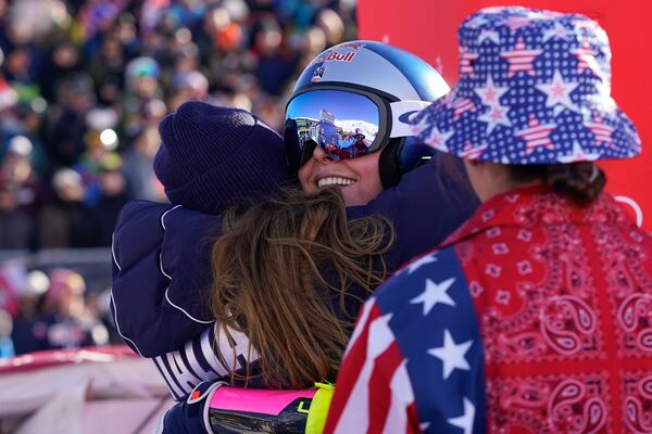 Italy's Sofia Goggia, left, hugs United States' Lindsey Vonn after Vonn competed in an alpine ski, women's World Cup super G, in St. Moritz, Switzerland, Saturday, Dec. 21, 2024. (AP Photo/Giovanni Auletta)