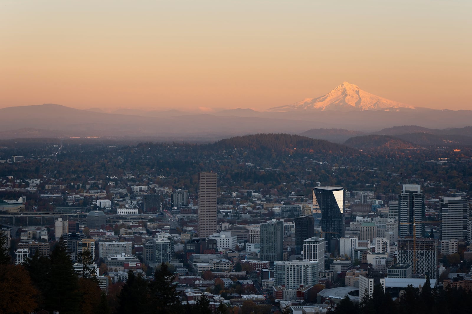 With Mount Hood in the background, the sun sets over downtown Portland, Ore., Wednesday, Nov. 6, 2024. (AP Photo/Jenny Kane, File)