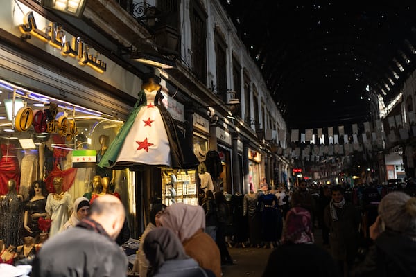 A dress with the new Syrian flag is displayed in a shop in Al-Hamidiyeh Souq on New Years Eve, in Damascus, Syria, Tuesday, Dec. 31, 2024. (AP Photo/Mosa'ab Elshamy)