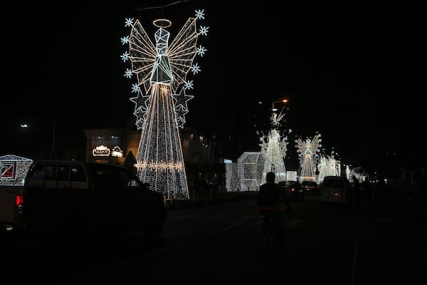 Cars drive past Christmas decorations on a street in Lagos, Nigeria, Friday, Dec. 20, 2024. (AP Photo/Sunday Alamba)