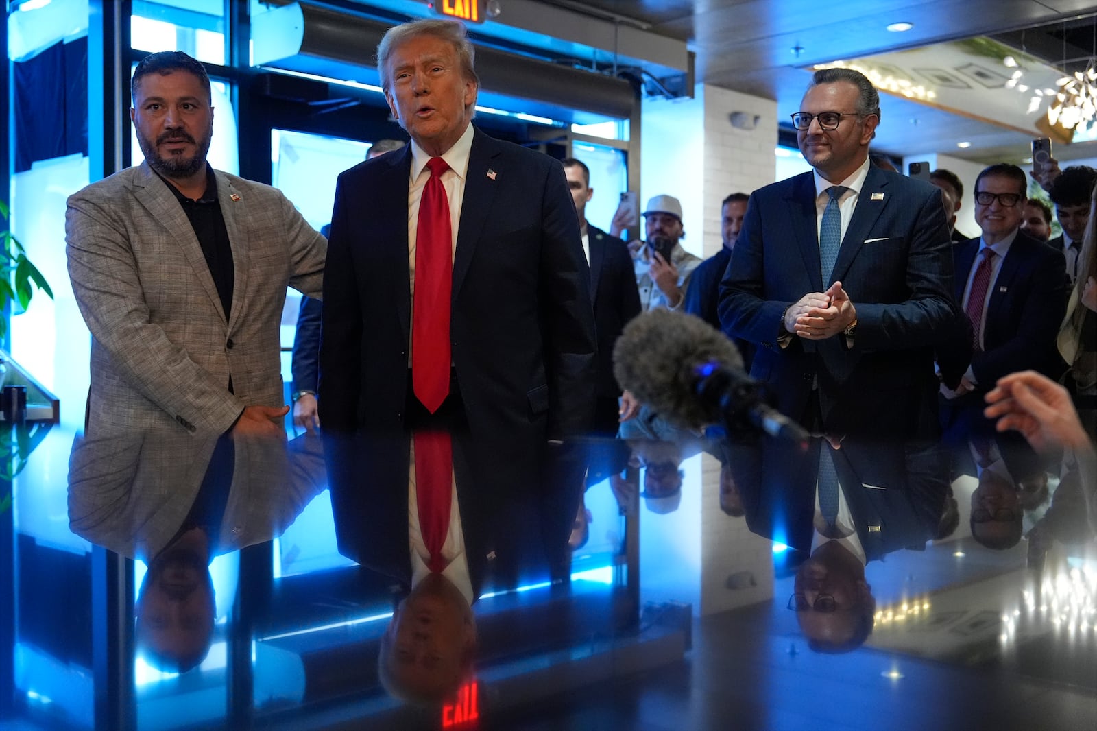 Republican presidential nominee former President Donald Trump visits The Great Commoner, Friday, Nov. 1, 2024, in Dearborn, Mich., as owner Albert Abbas, left, escorts him and Massad Boulos watches, (AP Photo/Julia Demaree Nikhinson)