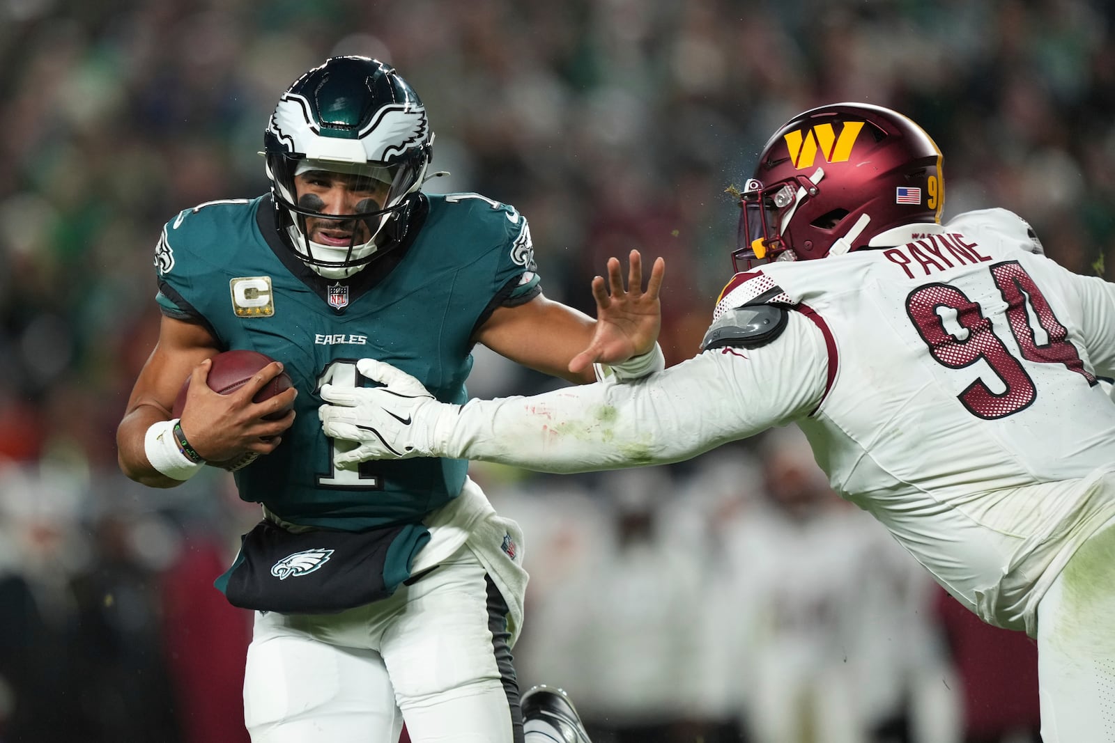 Philadelphia Eagles quarterback Jalen Hurts (1) runs as Washington Commanders defensive tackle Daron Payne (94) defends during the first half of an NFL football game Thursday, Nov. 14, 2024, in Philadelphia. (AP Photo/Matt Slocum)