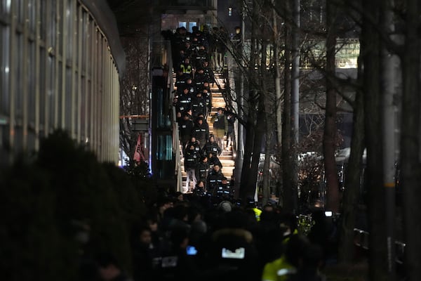 Police officers walk to the gate of the presidential residence in Seoul, South Korea, Wednesday, Jan. 15, 2025. (AP Photo/Lee Jin-man)